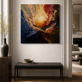 Abstract canvas wall art featuring a swirling cosmic scene with a bright yellow-white sun-like center, red and orange clouds, and deep blue areas, displayed in a styled interior above a dark bench.